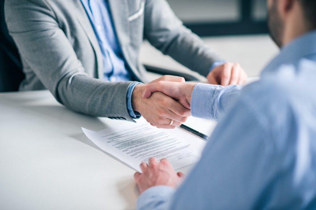 Business partnership concept. Cropped image of two businessmen handshake.